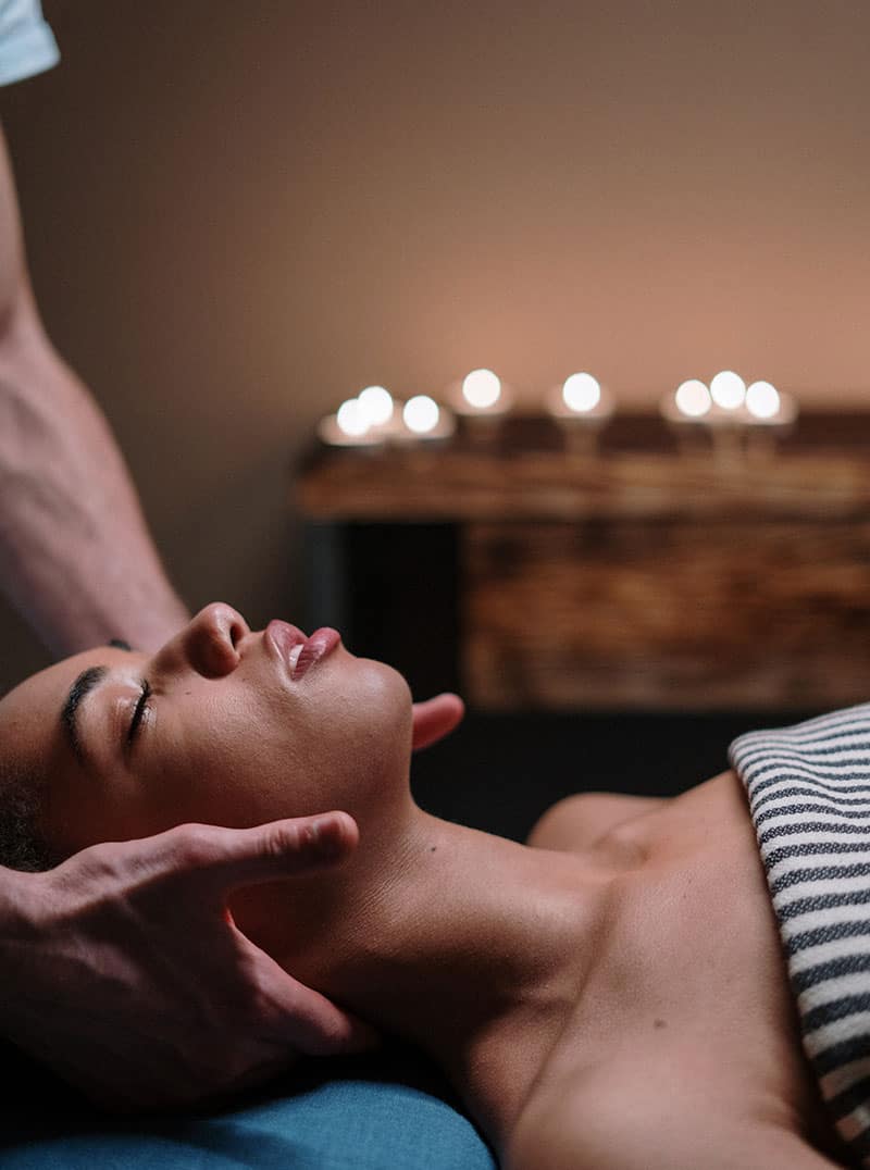 Woman receiving relaxing head massage with candles