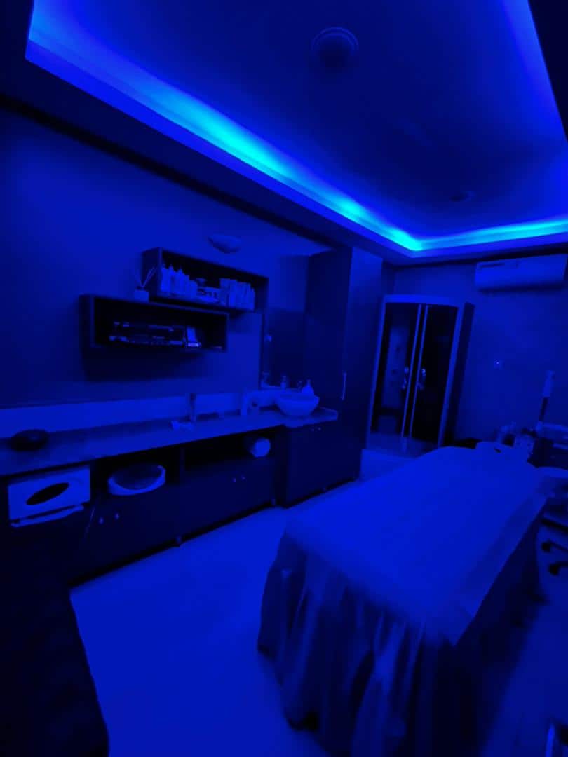 Blue-lit spa treatment room with massage table