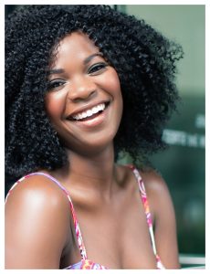 Smiling woman with curly hair in floral top