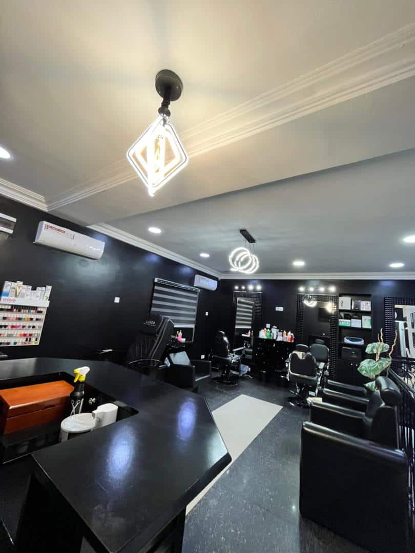Modern black-themed hair salon with styling chairs