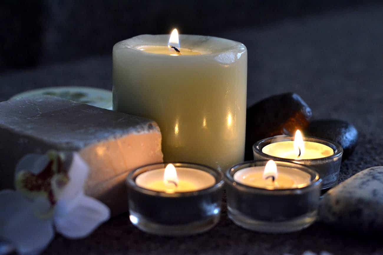 Lit candles with spa stones and soap bar
