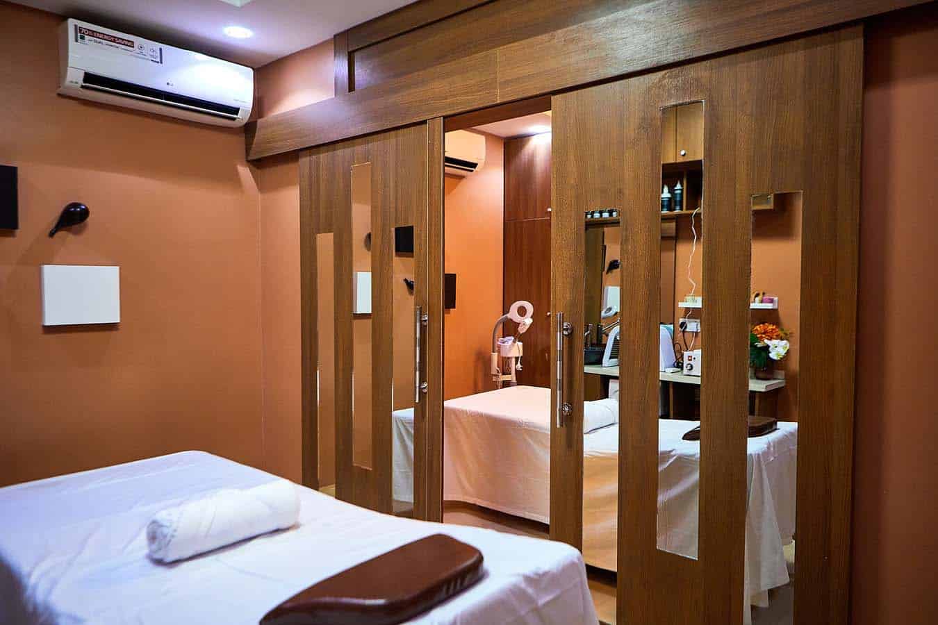 Modern beauty treatment room with massage bed and mirrors
