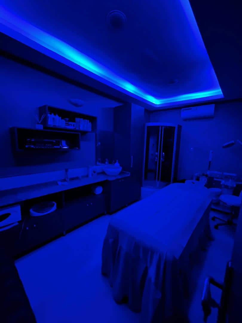 Blue-lit spa treatment room with massage table