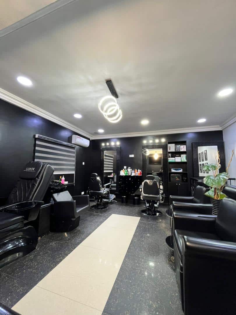 Modern black-themed hair salon with barber chairs