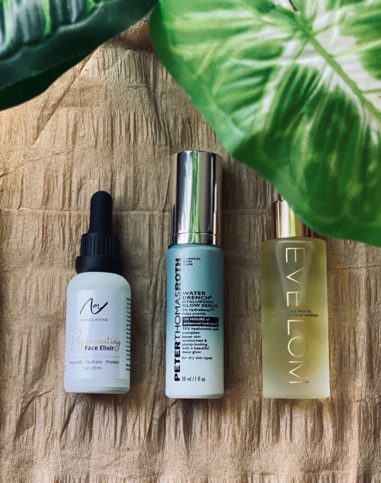 Three skincare serums on wooden surface with leaves