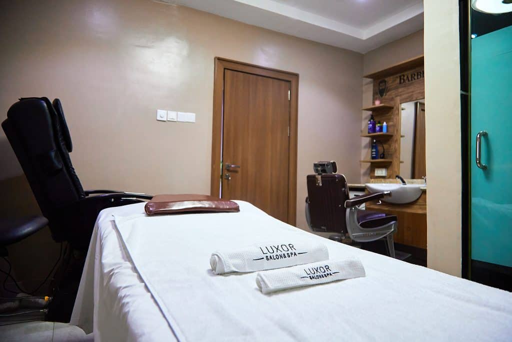Salon treatment room with massage bed and sink