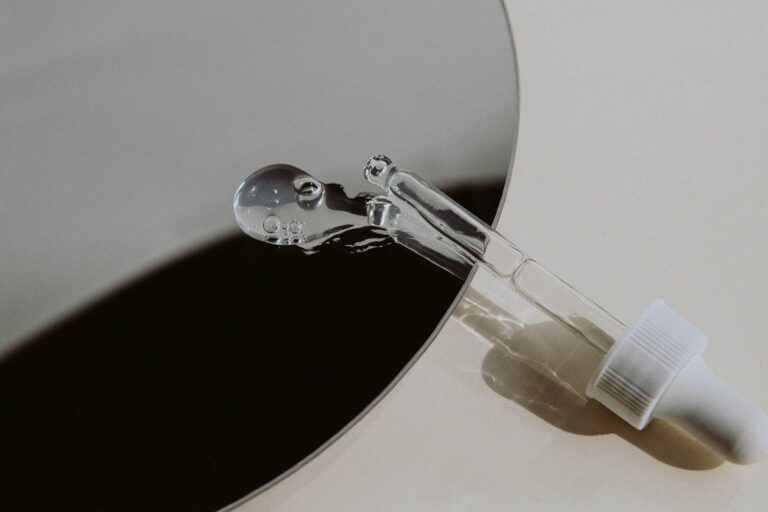 Glass dropper with serum droplet on mirror