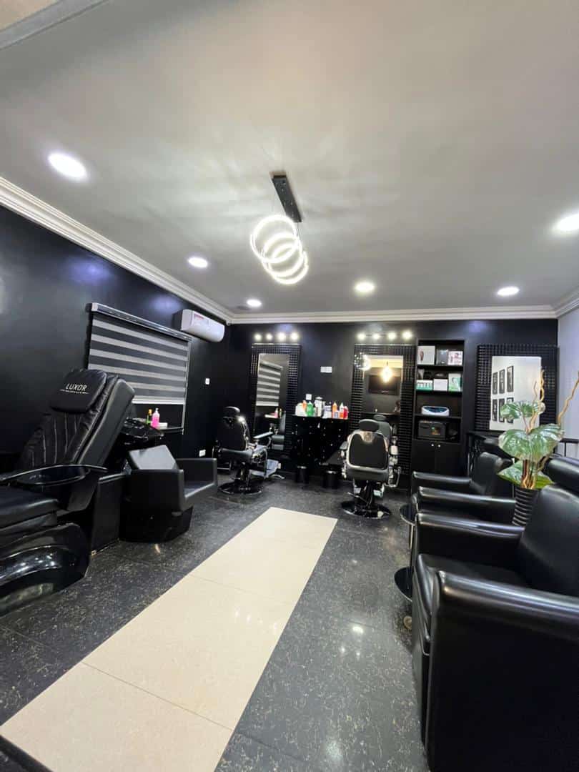 Modern black-themed barbershop interior with styling chairs