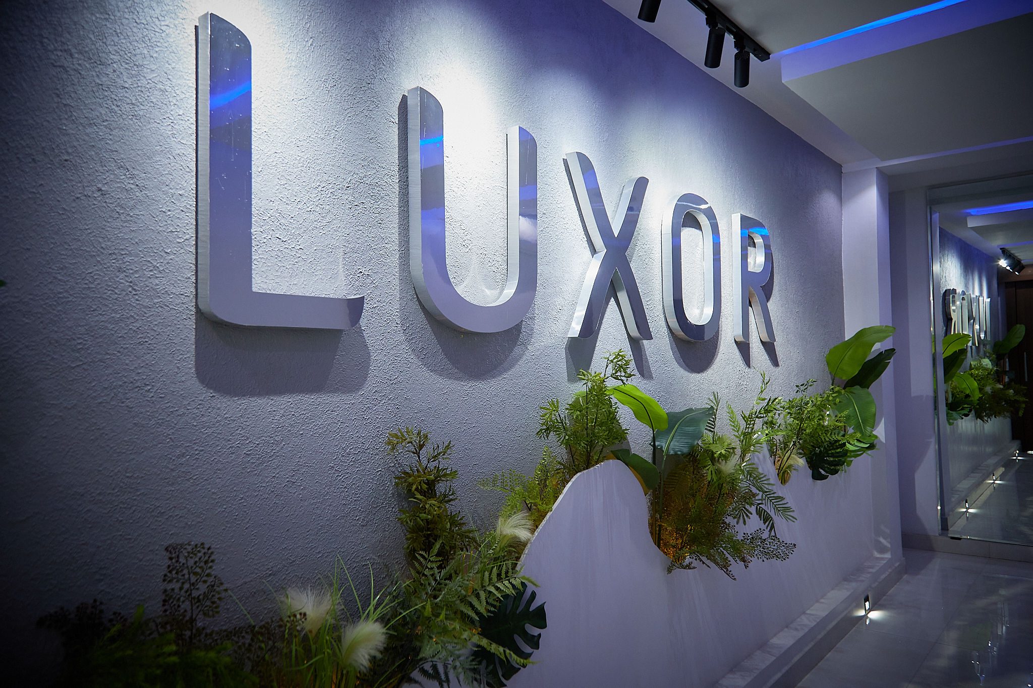 Metallic LUXOR sign on modern interior wall