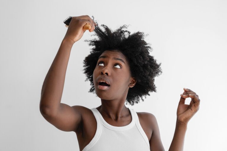 Woman struggling with tangled hair and hairbrush