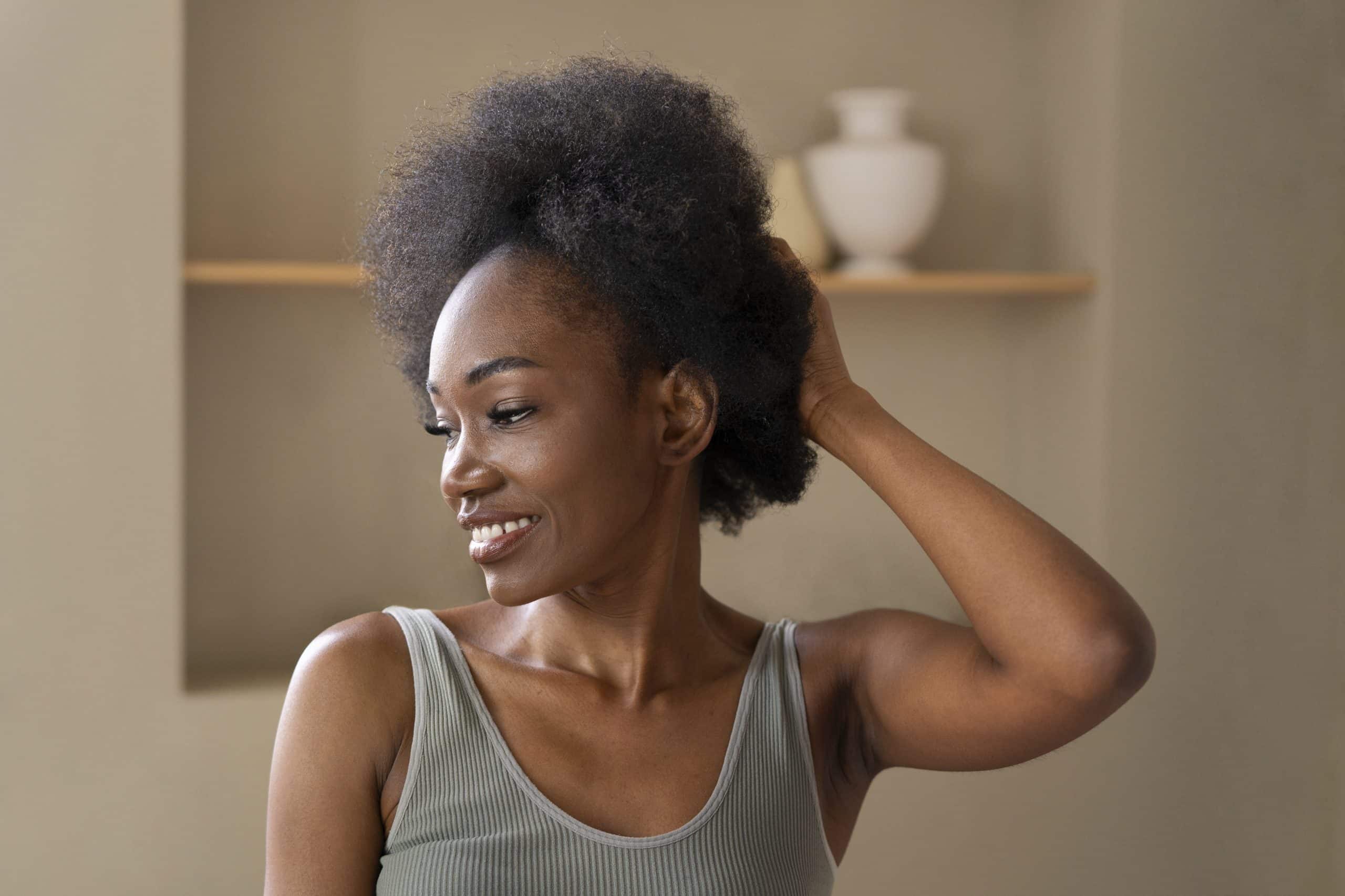 Woman smiling with natural afro hairstyle indoors