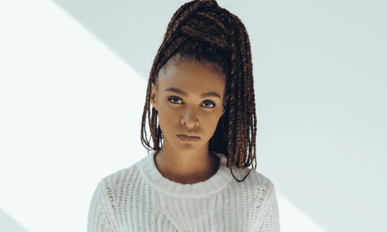 Woman with braided hair wearing white jumper