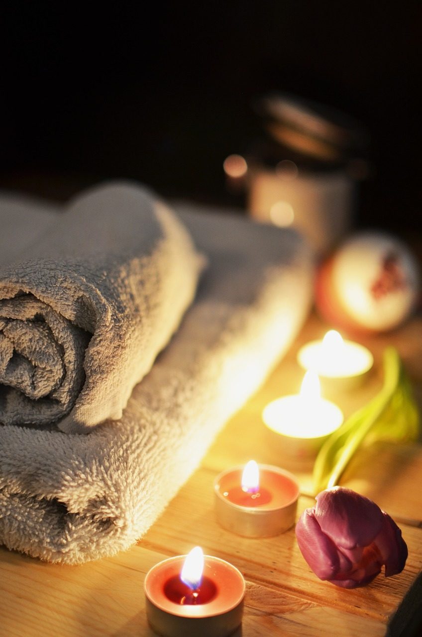 Rolled towels and candles in relaxing spa setting