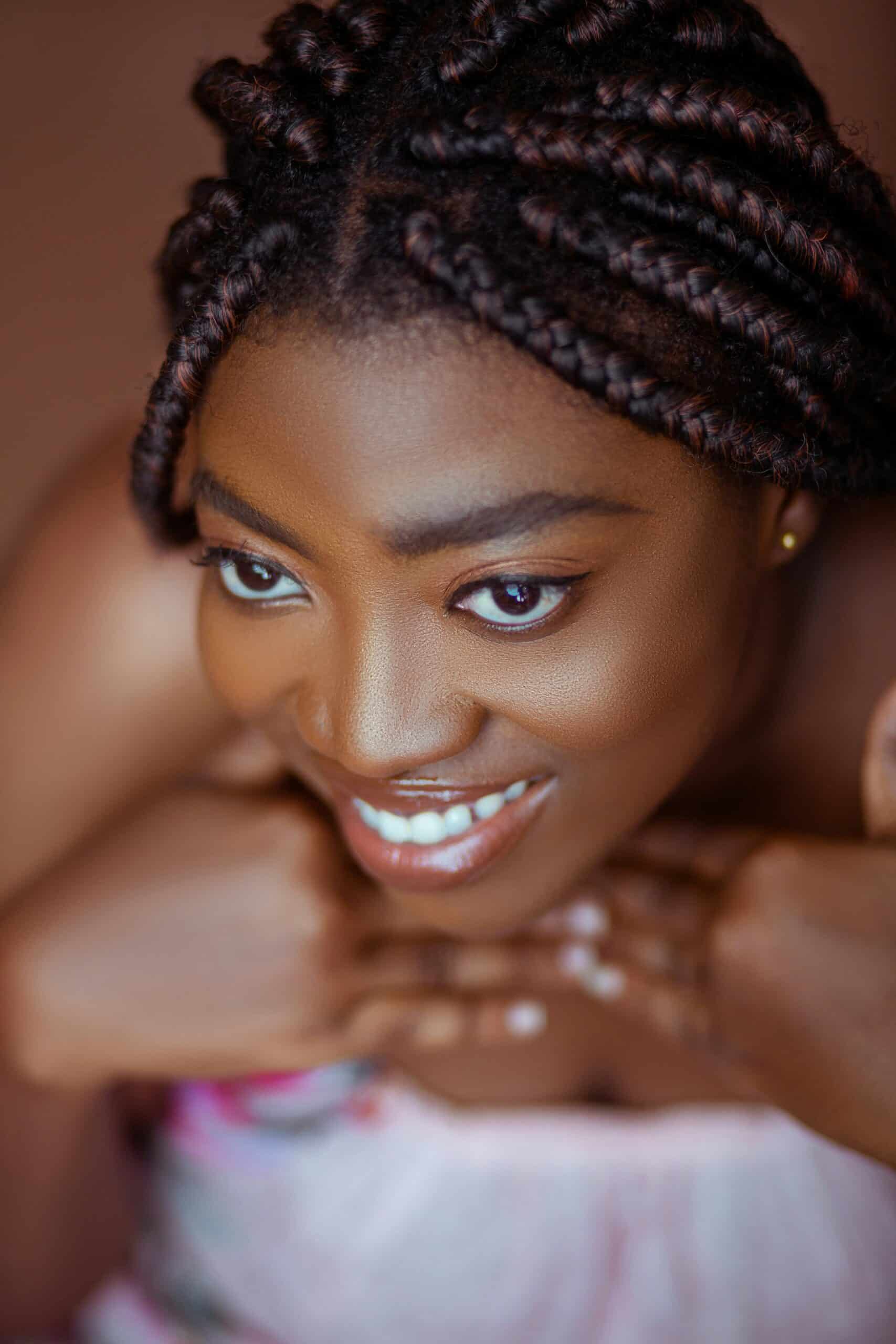 Smiling woman with braided hair resting on arms