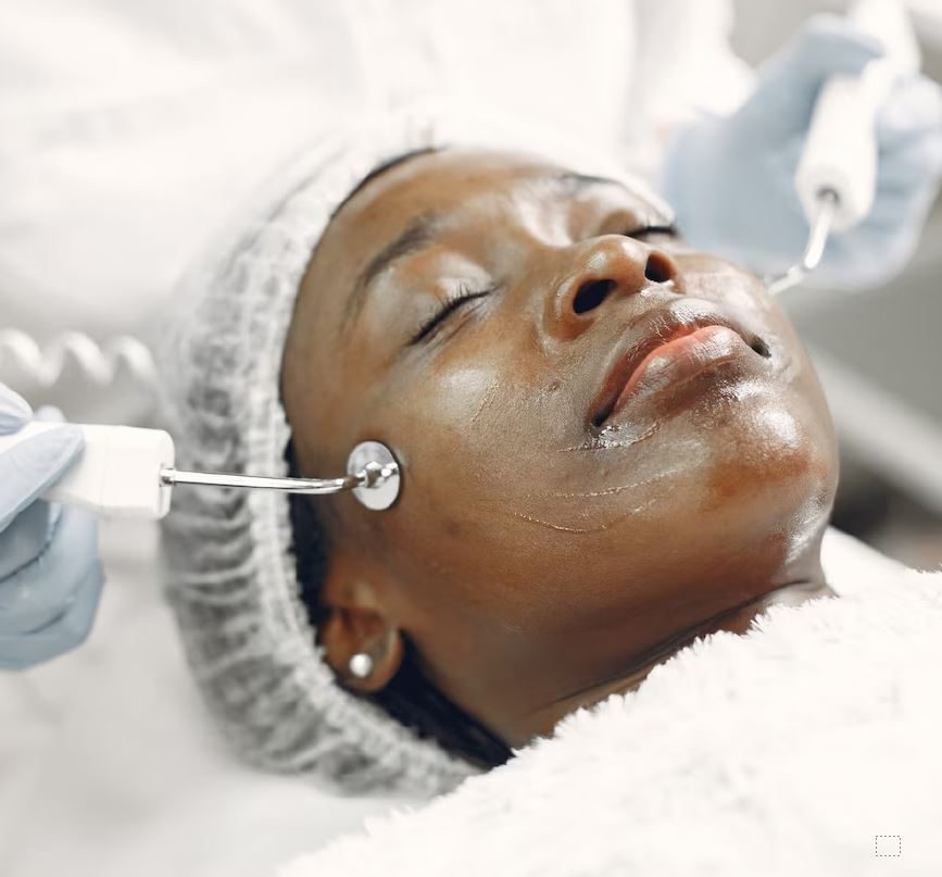 Woman receiving facial treatment with skincare device