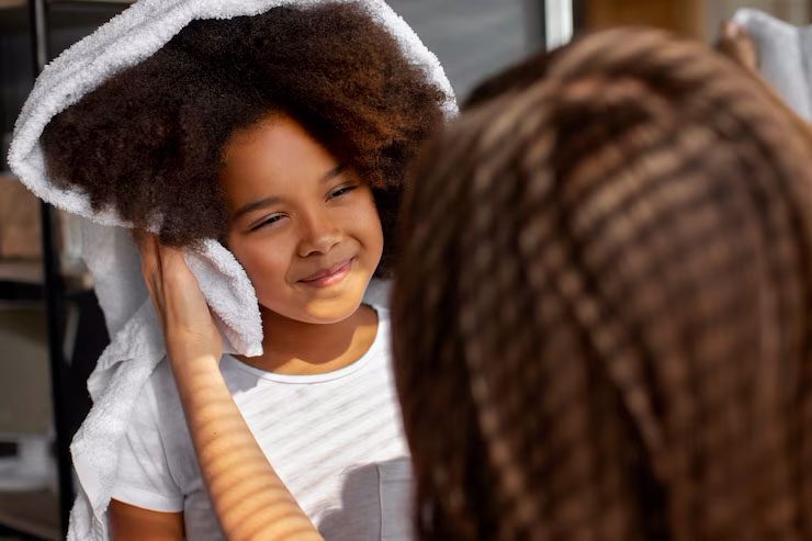 Smiling child with towel on head after bath