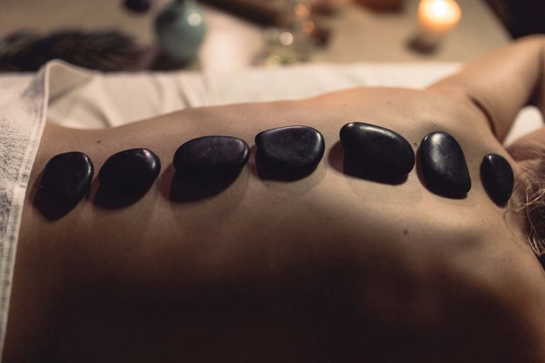 Hot stone massage with black stones on back