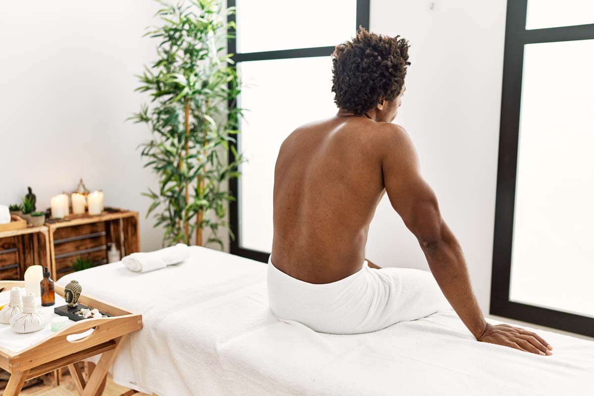 Man sitting on massage table in spa room