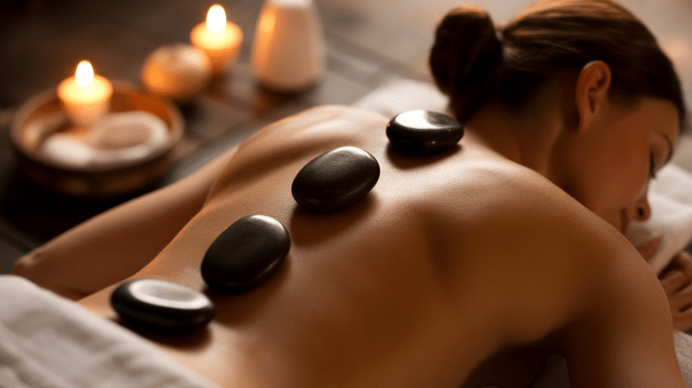 Woman receiving hot stone massage with candles