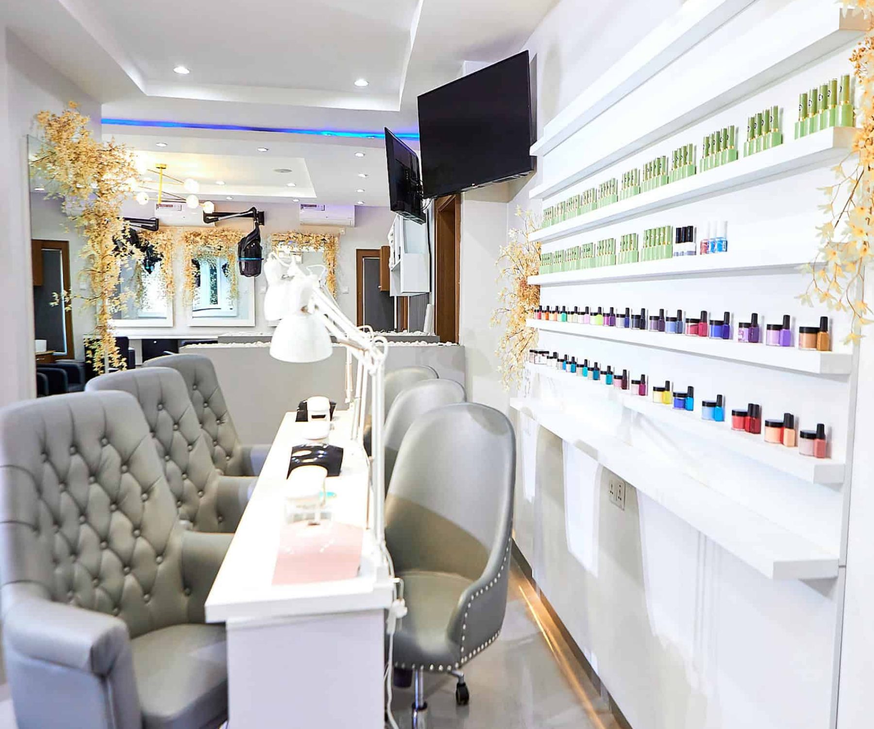 Modern nail salon interior with manicure stations and polish display
