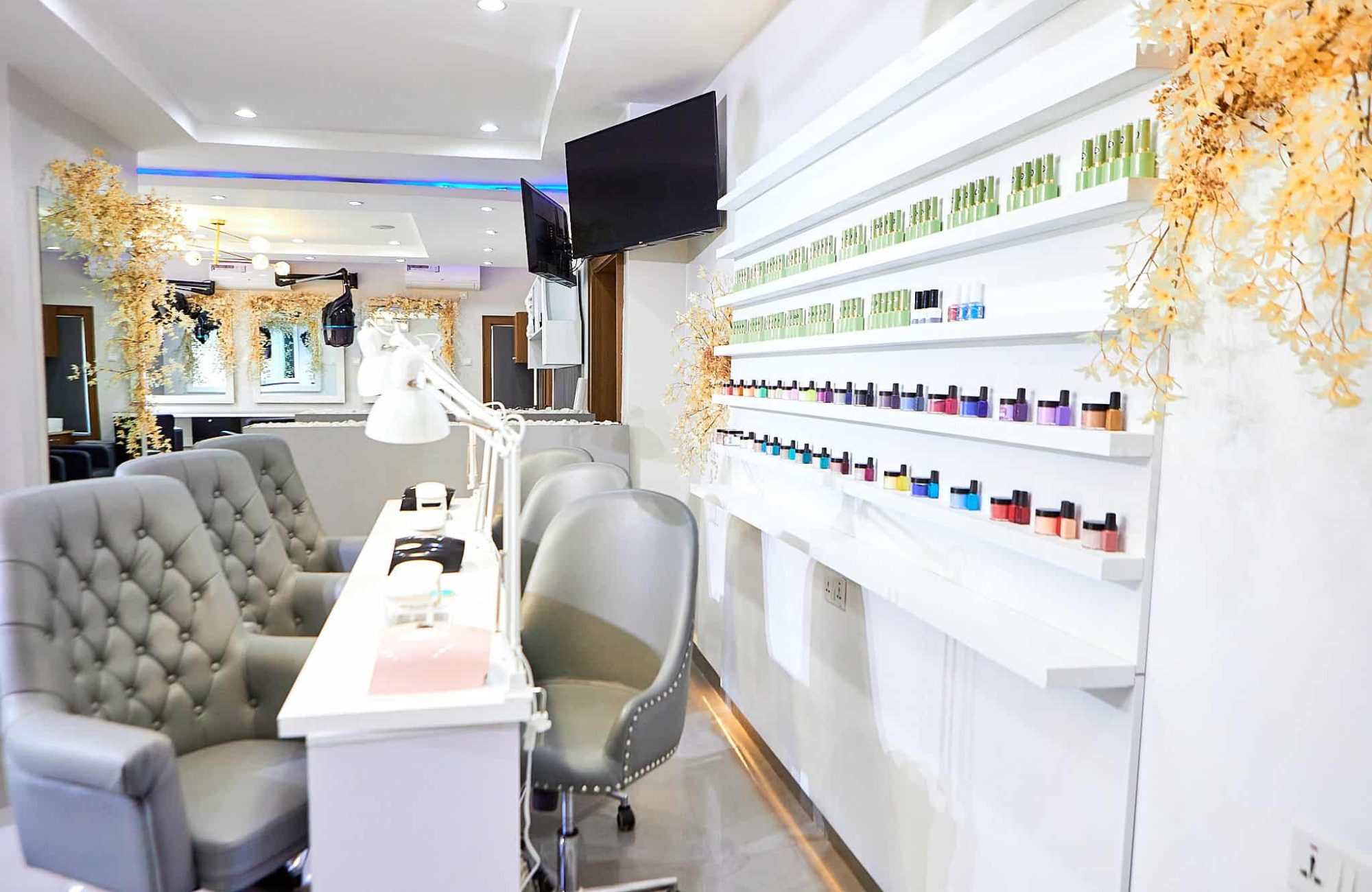 Modern nail salon interior with manicure stations and polish display
